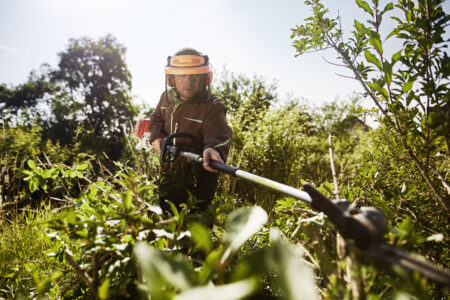 Ein Mitarbeiter - Garten- und Landschaftsbau - bei der Grünpflege.