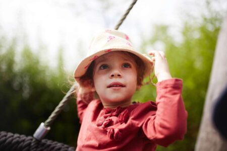 Ein junges Mädchen spielt zufrieden auf dem Spielplatz.