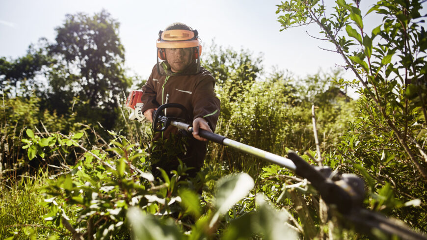 Ein Mitarbeiter - Garten- und Landschaftsbau - bei der Grünpflege.