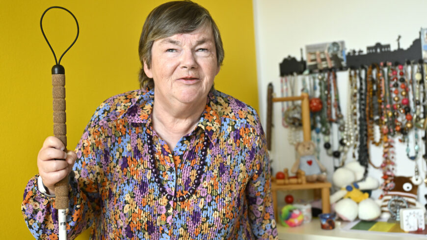 Blinde Frau blickt zufrieden in die Kamera.